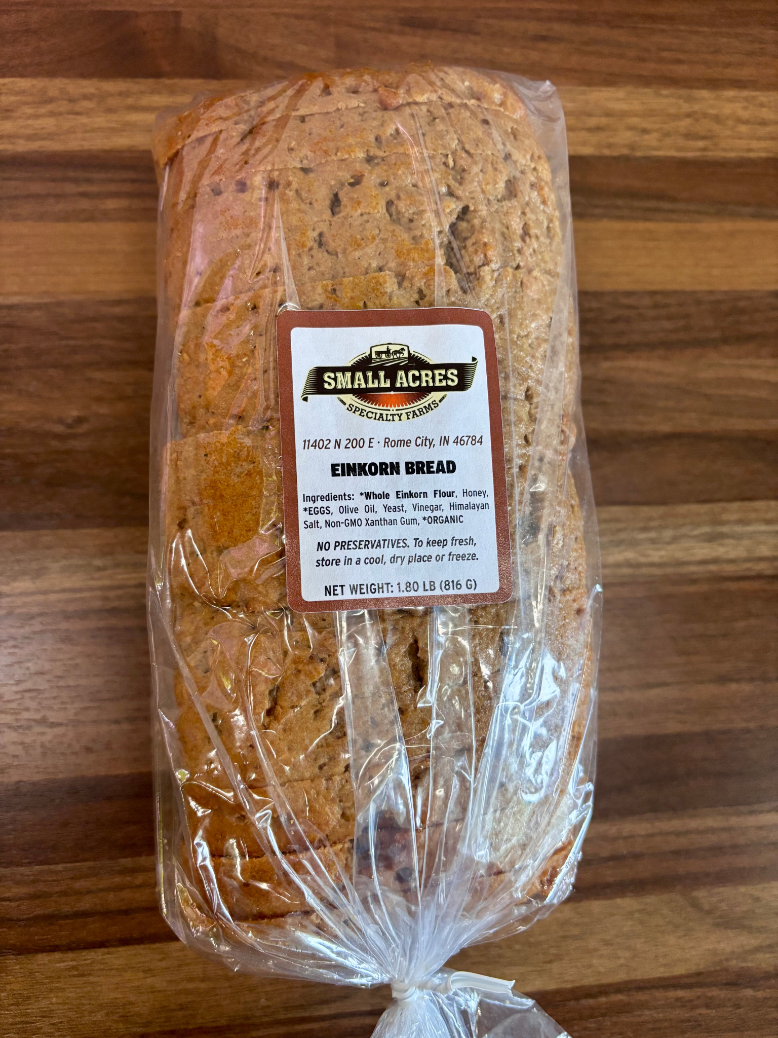 Packaged loaf of bread with a label on a wooden surface